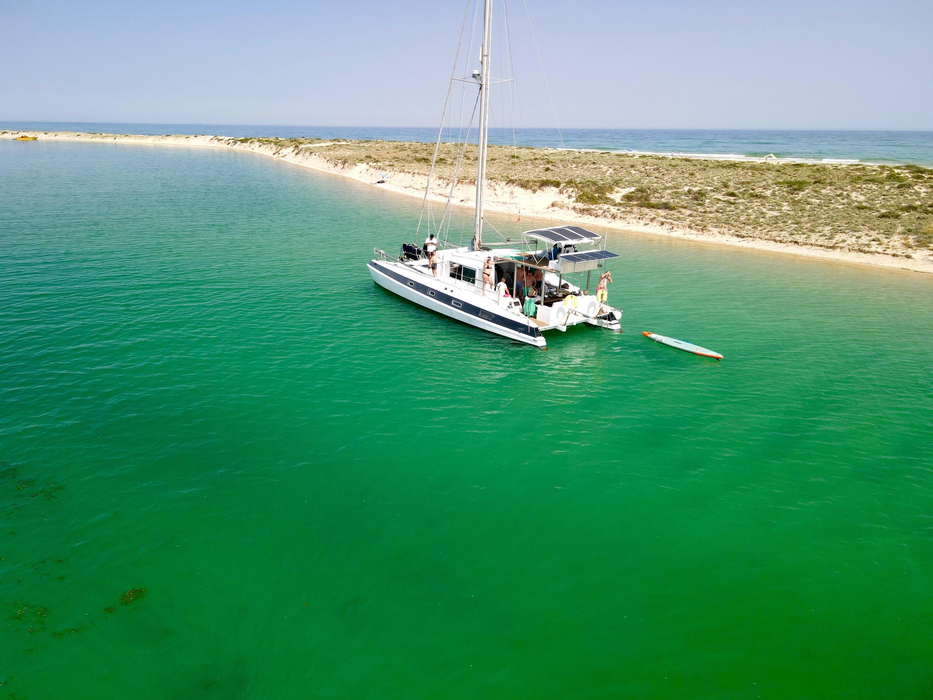 Guests on the catamaran with a paddleboard in the lagoon